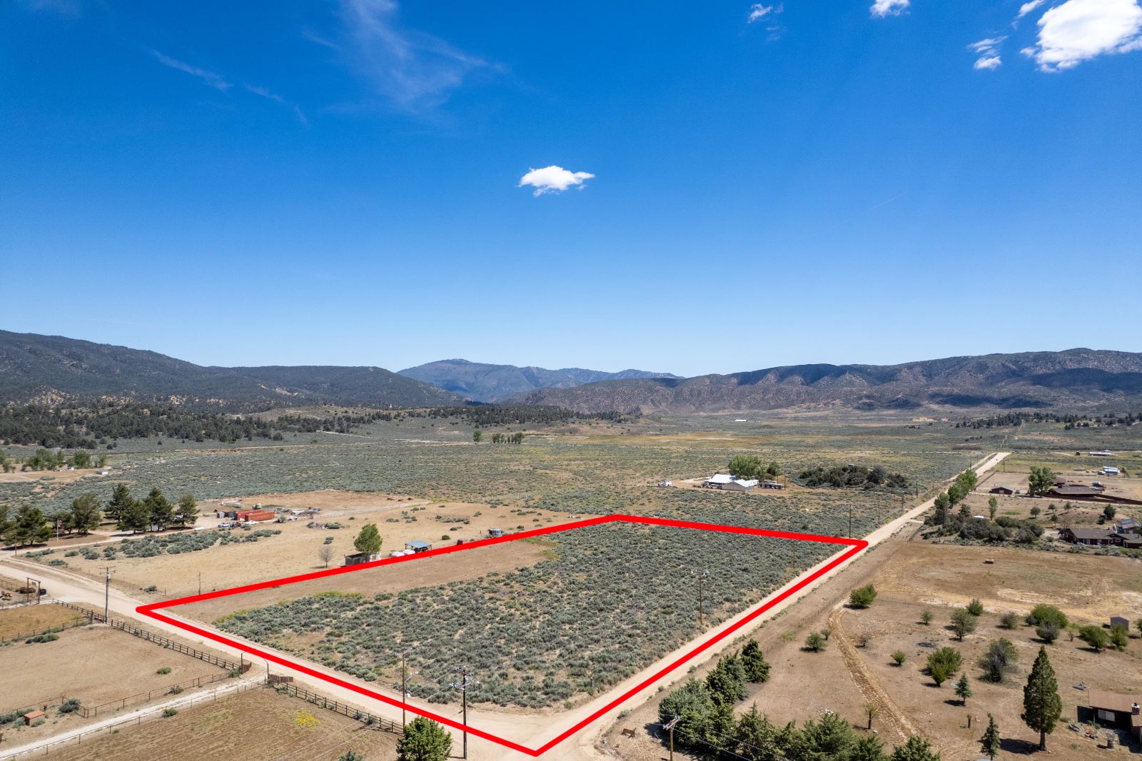 Vacant acreage outlined in red against the valley and the far ridgeline