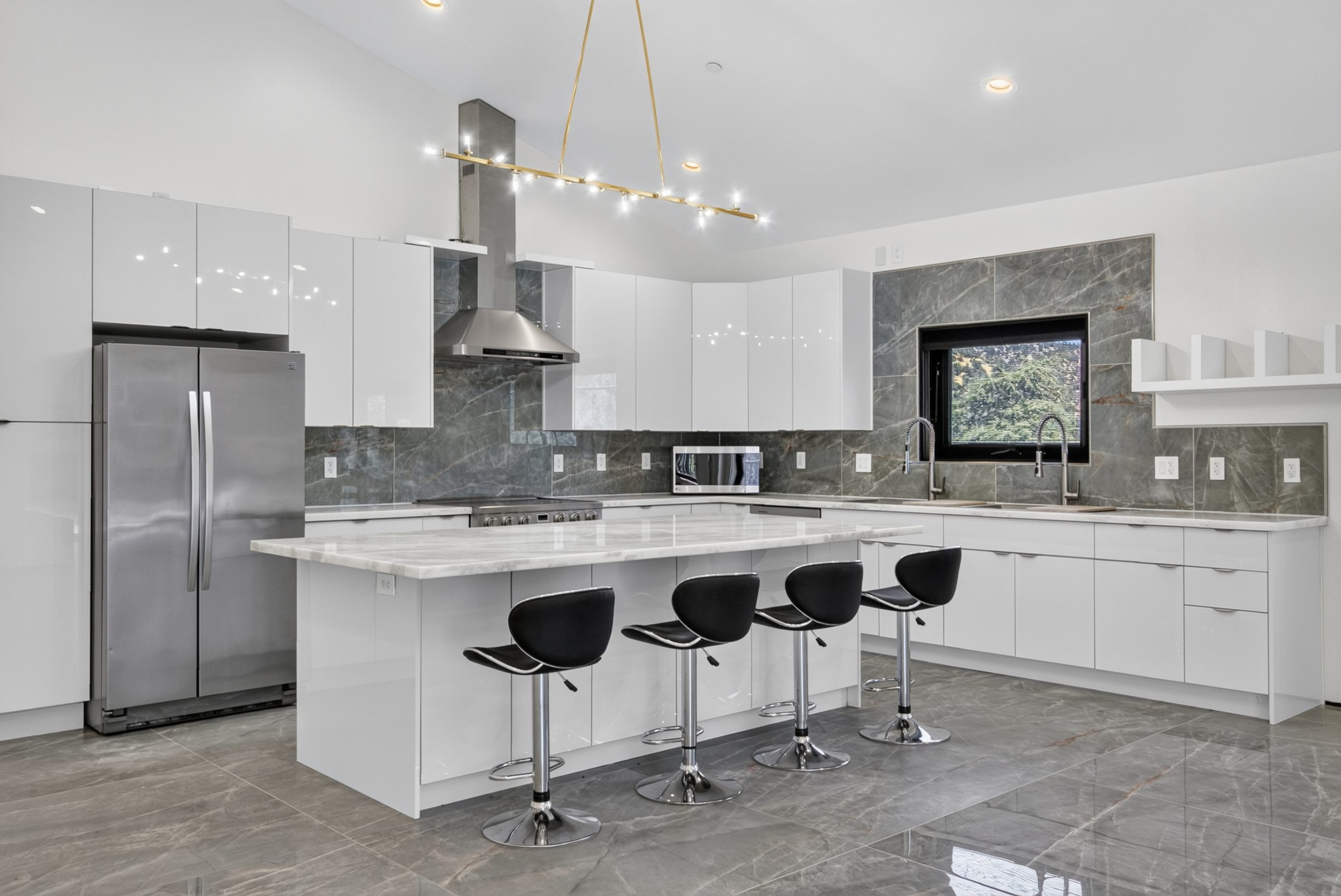 White kitchen with a waterfall island and black bar stools