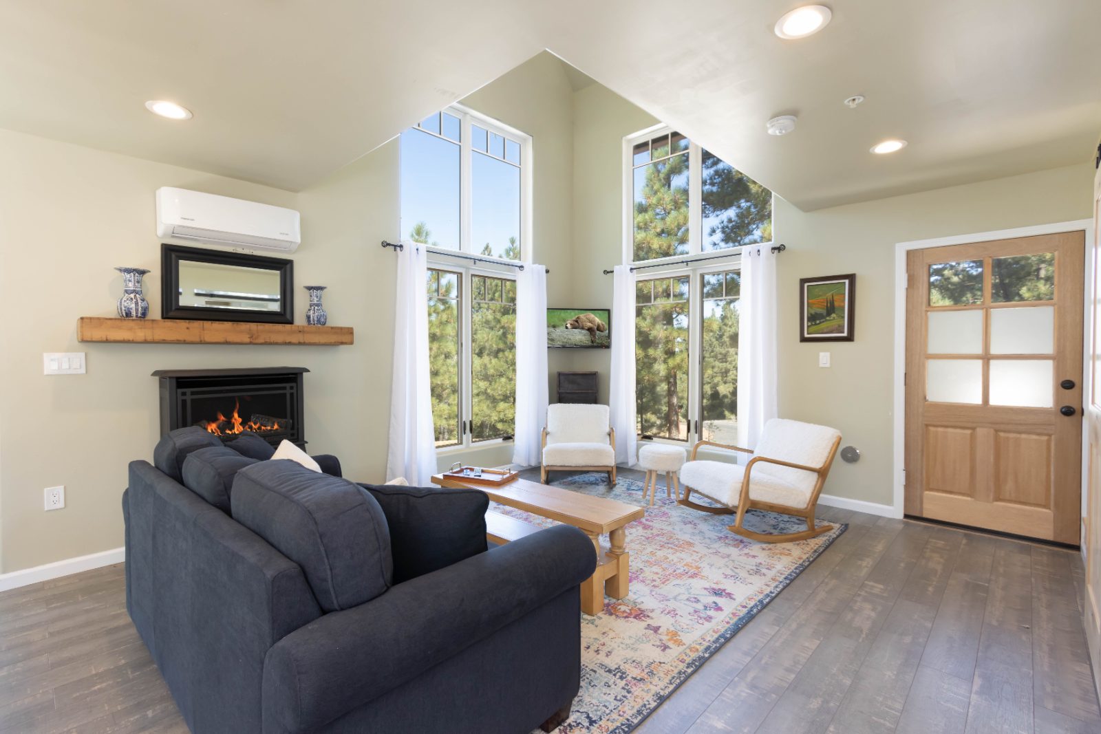 Living room with stone fireplace and tall windows