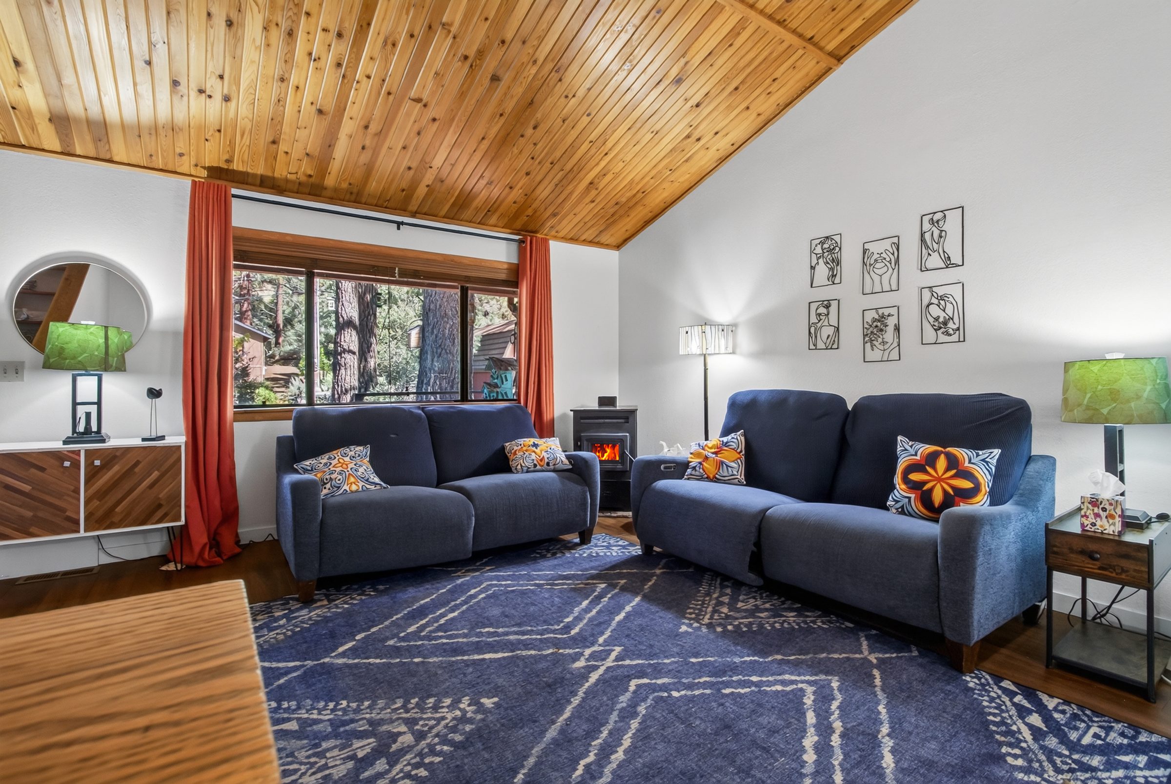 Living room with blue sofas under a cedar ceiling