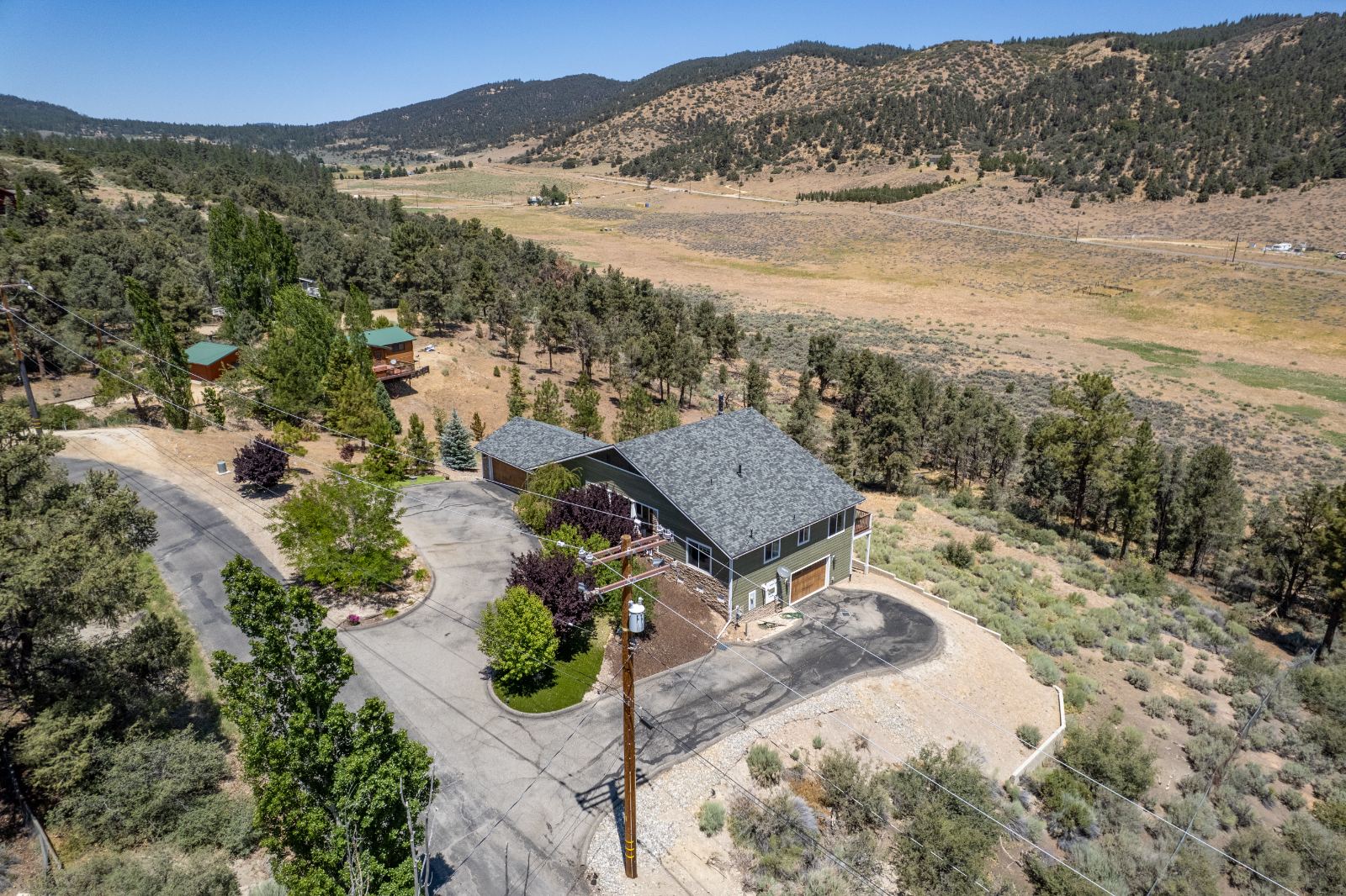 Aerial view of a home, drive and the valley beyond