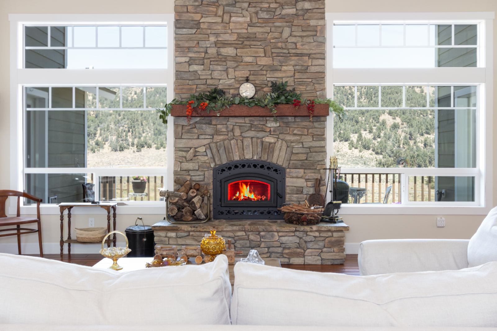 Stone fireplace lit, flanked by windows onto the ridge