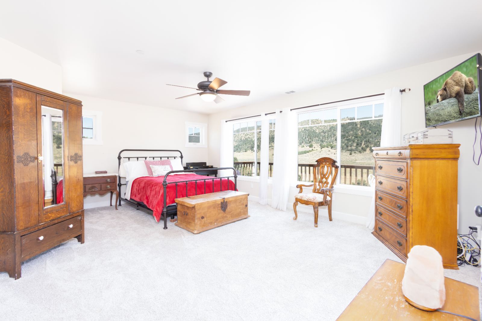 Primary bedroom with antique wardrobe and windows onto the hills