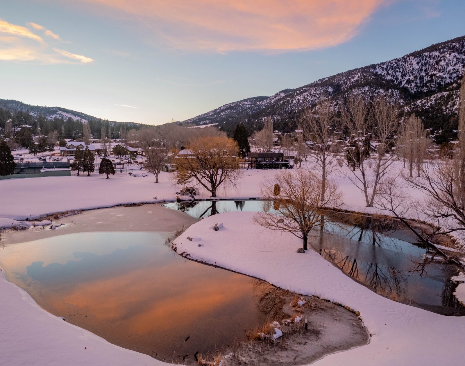 Snowy lake reflecting a pink sunset
