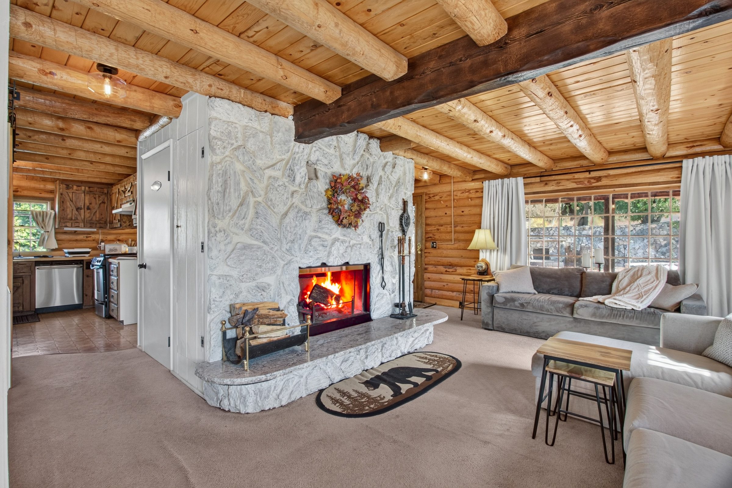 Log living room with a white stone fireplace